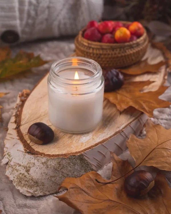 Cozy comforting autumn candle with leaves
