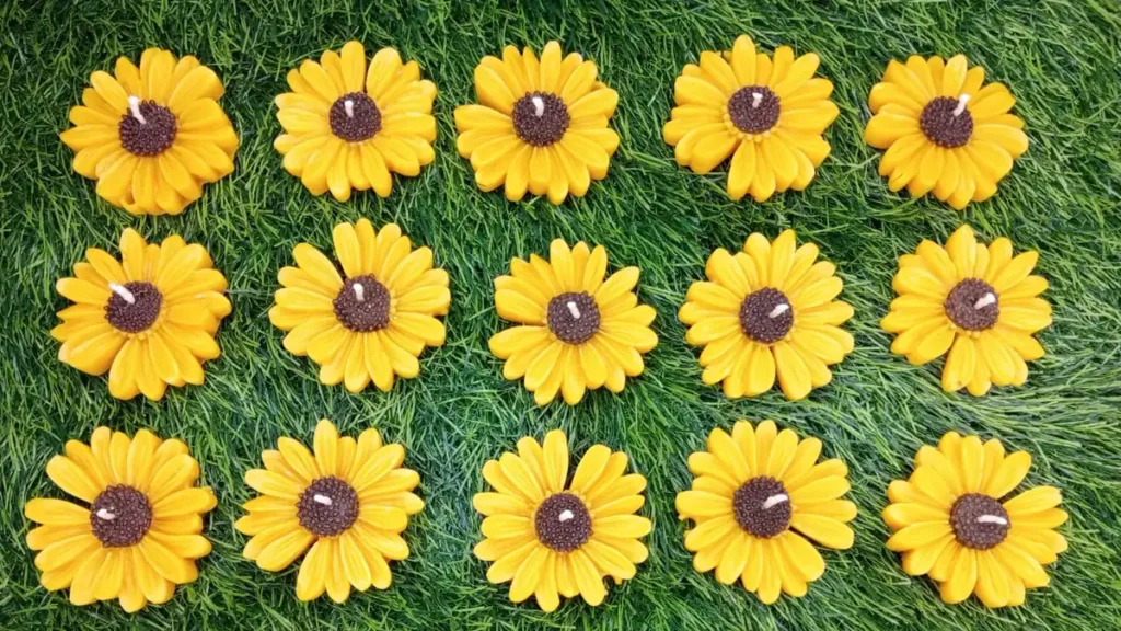 Yellow daisy floating candles laid out for a wedding favour order, handmade by Candle Studio Lahore
